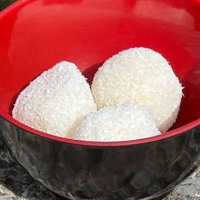 Trois perles de coco roulées dans la noix de coco râpée.