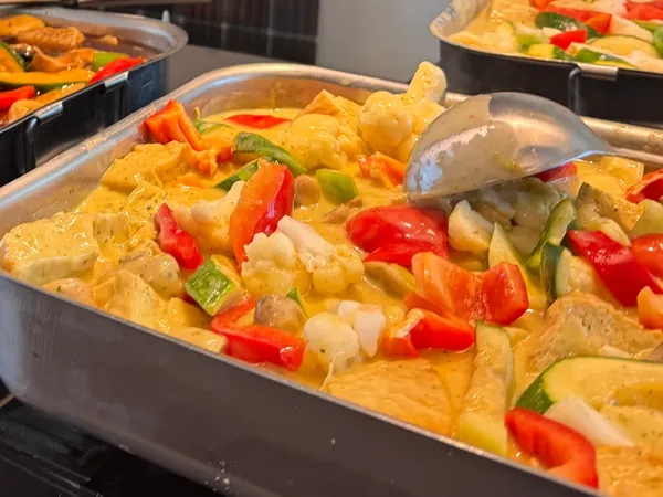 Un bac de curry aux légumes et au tofu, sur son réchaud.