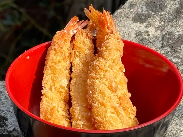 Trois beignets de crevettes dorés.